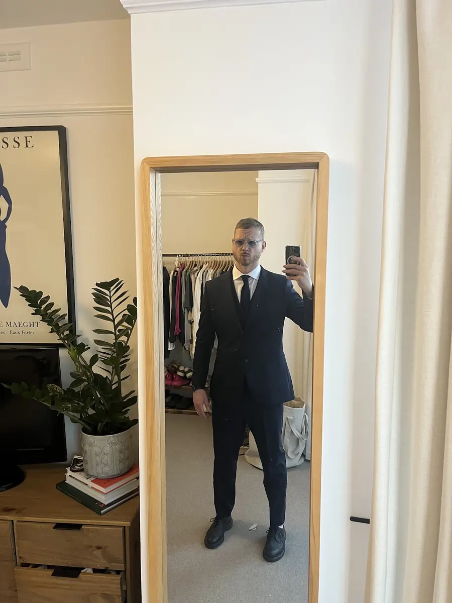 A finished dark three-piece suit seen in the fitting room